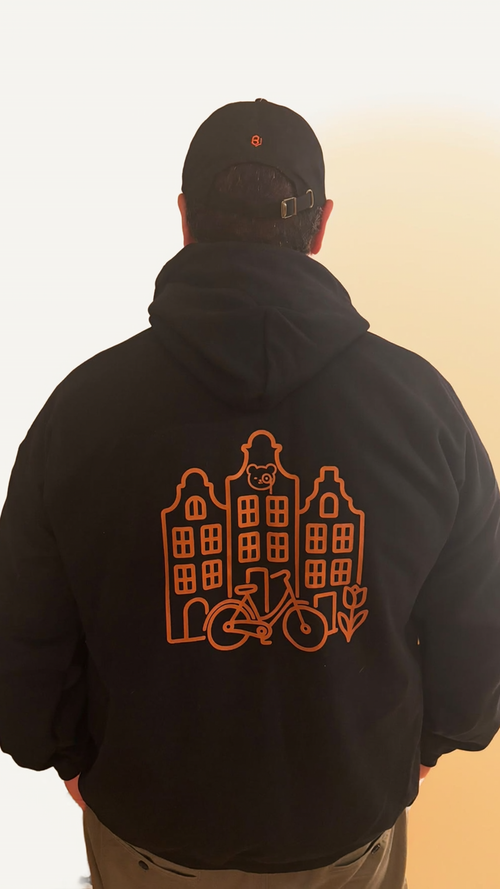 Back of the black Amsterdam Minimal hoodie: copper canal houses, bicycle and tulip with Teddy O'Broin in the window