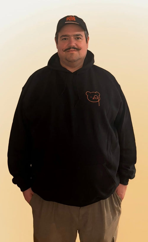 Man wearing the black Amsterdam Minimal hoodie with the Teddy O'Broin chest print in copper