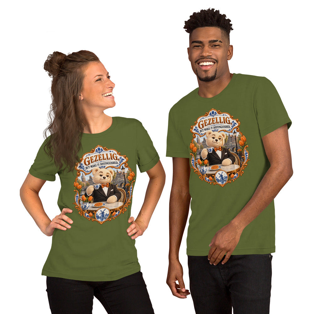 Olive T-shirt featuring Teddy O’Broin wearing a tuxedo and monocle beside an Amsterdam canal with tulips, a Delft cup and stroopwafel beneath the words Gezellig, But Make It Distinguished.